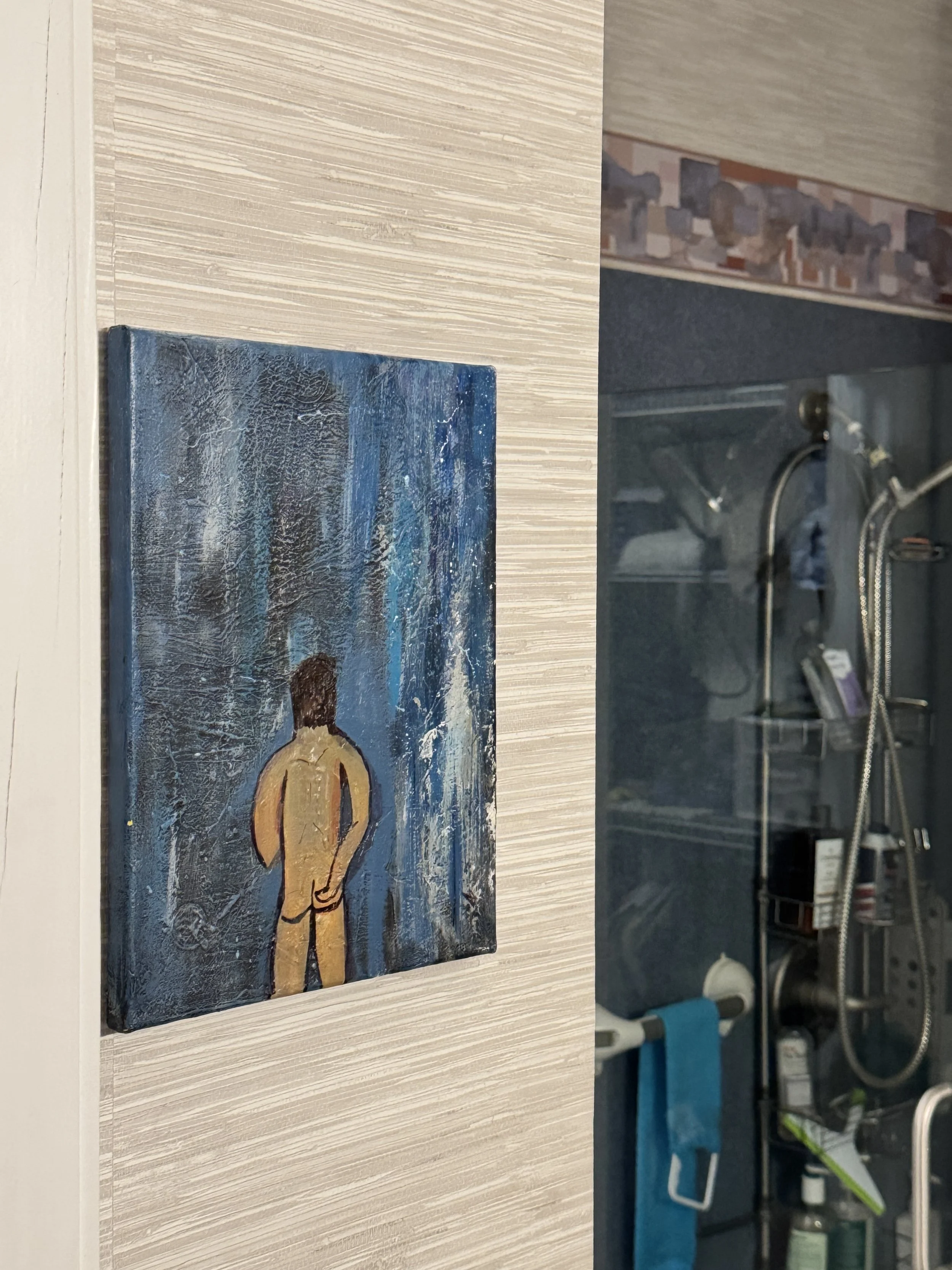 A small painting of a person from behind, standing in a stormy blue background, hangs on a textured beige wall.