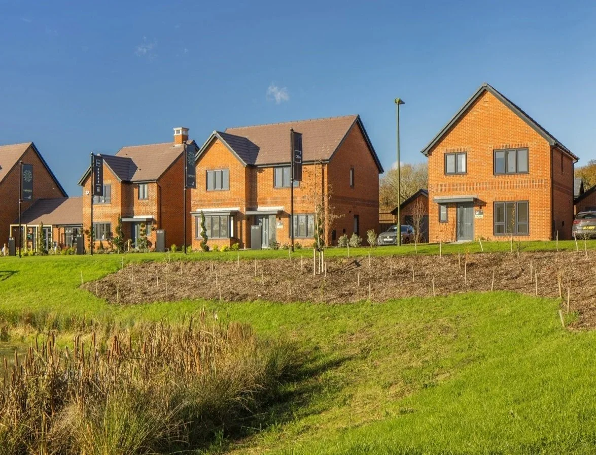 Forest Edge, Wood End precedent image, with green grass hill area in front of houses.