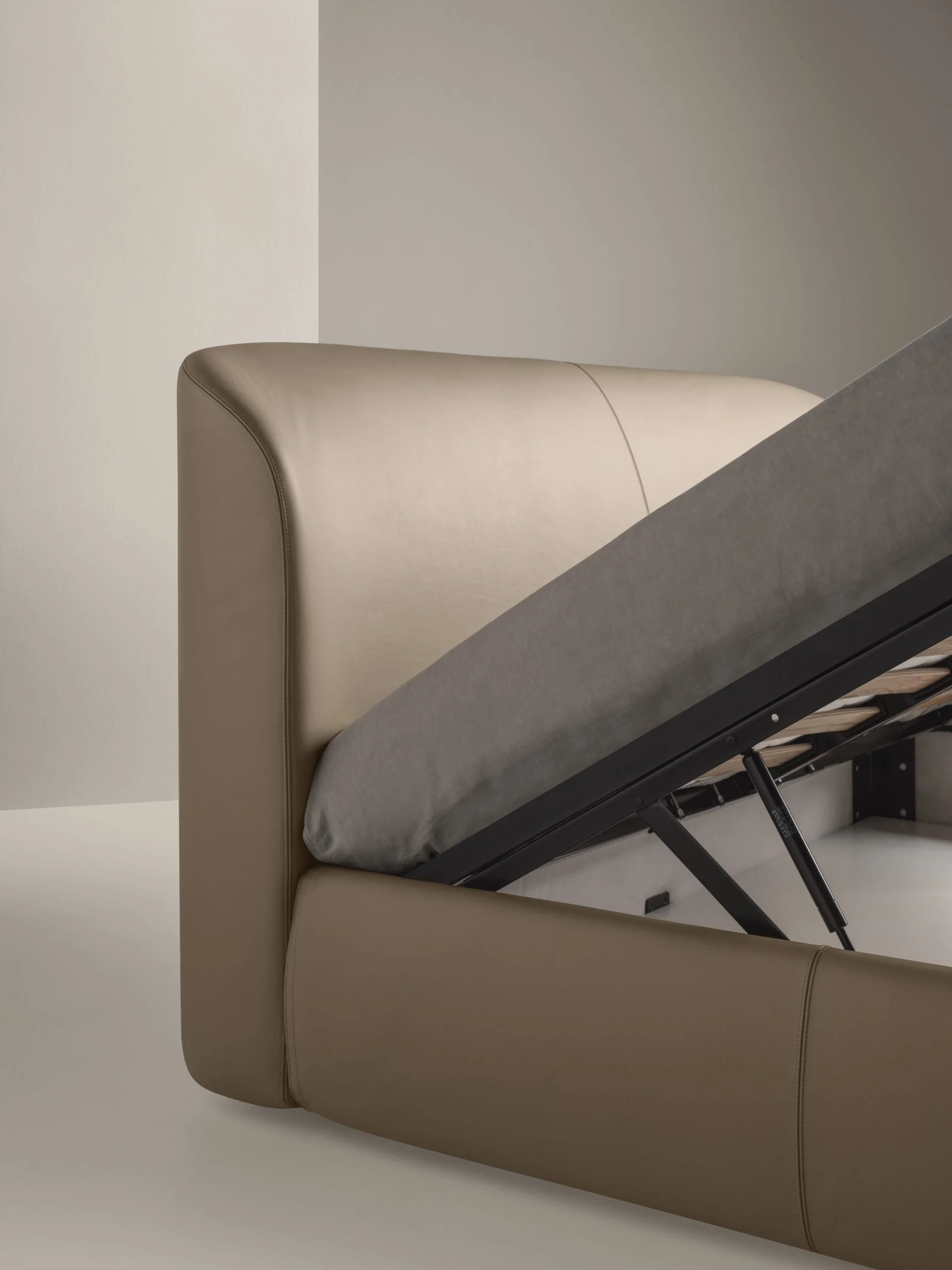 Italian Loren bed by Frag with practical lift-up storage base in beige leather at ArkNova Interiors Paphos showroom in Cyprus