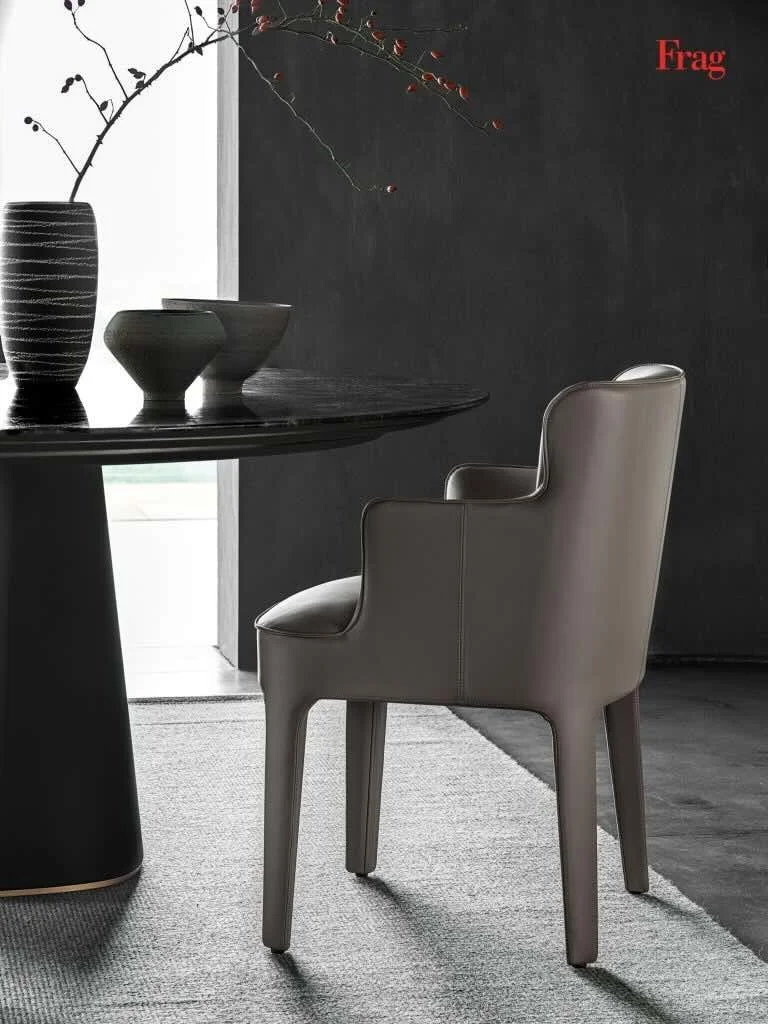 Frag Public P Italian gray leather dining armchair at black table at ArkNova Interiors Paphos showroom in Cyprus
