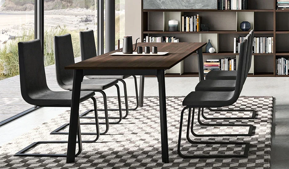 Cinquepuntozero Otello Italian dark wood rectangular dining table with black cantilever chairs on checkered rug at ArkNova Interiors Paphos showroom in Cyprus