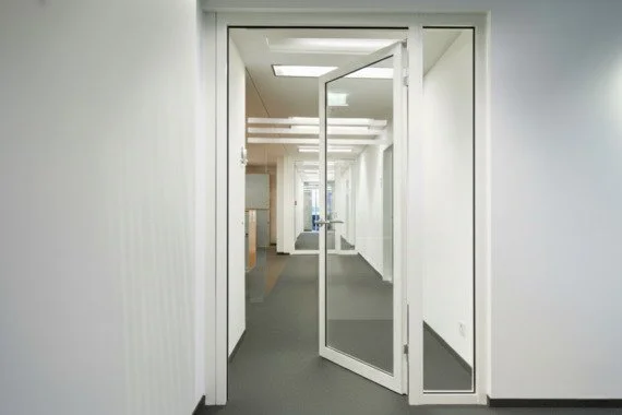 Novoferm Novofire Italian white framed glass fire-rated door open in office corridor at ArkNova Interiors Paphos Cyprus