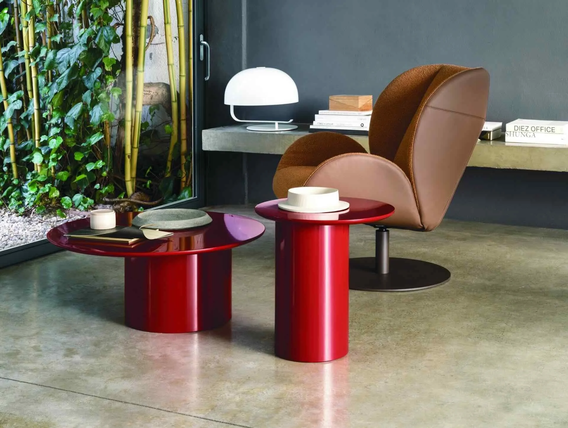 Frag Myon 48 Italian round glossy red side tables beside brown leather chair, modern design at ArkNova Interiors Paphos showroom in Cyprus