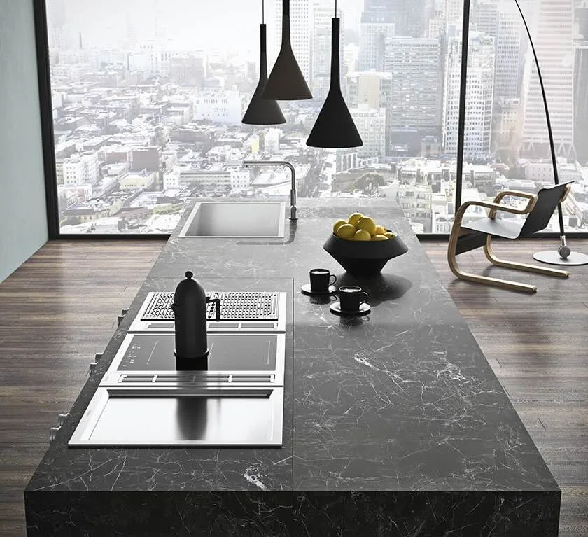 Antares Cucine AS10 CITY Italian design black marble kitchen island with sink, induction cooktop, French press and fresh lemons overlooking the city in Paphos, Cyprus by ArkNova Interiors