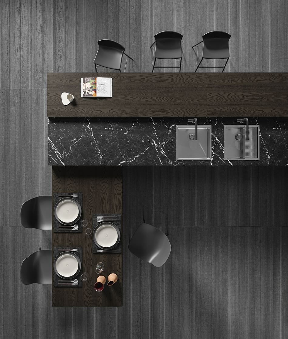 Antares Cucine MK18_L Italian modern kitchen top view of black marble island with dual sinks, integrated dining area and black chairs at ArkNova Interiors in Paphos Cyprus