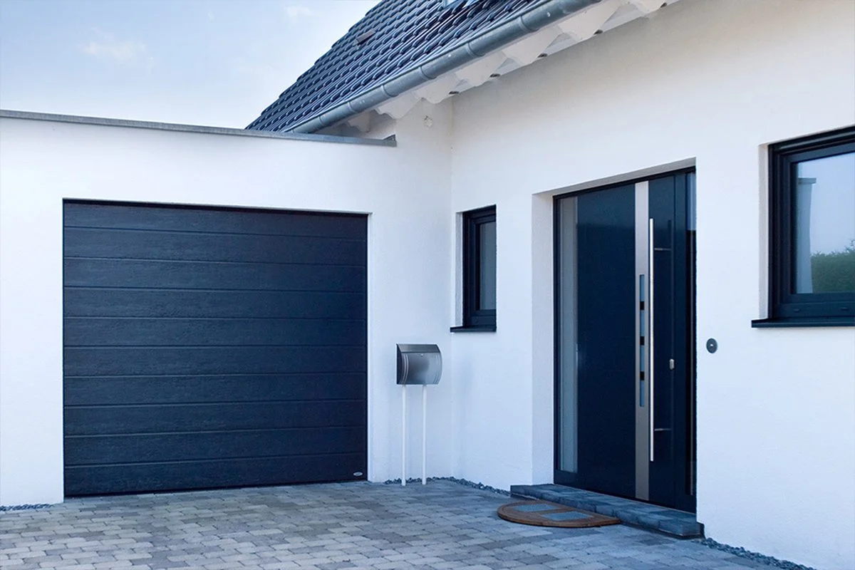 Novoferm Garage Sectional ISO 20 Italian dark wood-look sectional garage door on modern house at ArkNova Interiors Paphos Cyprus
