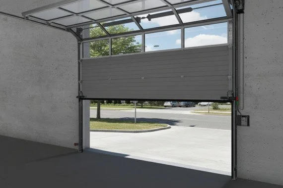 Novoferm Fuses Italian gray sectional industrial door partially open with upper windows at ArkNova Interiors Paphos Cyprus