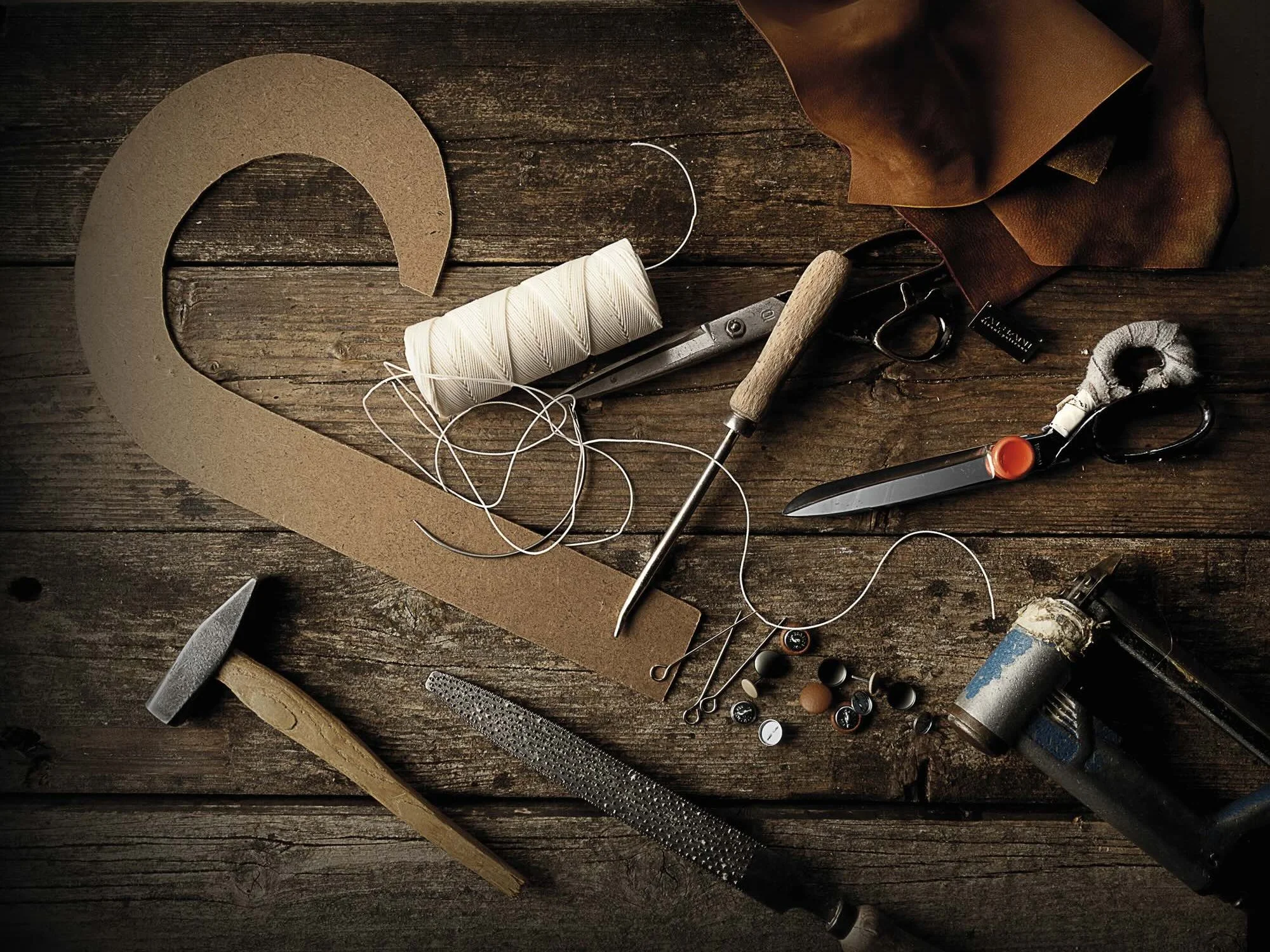 Authentic Italian leather craft tools and materials on a wooden workbench | ArkNova Interiors