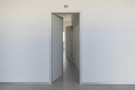 Novoferm Asia Italian modern gray fire-rated door open in corridor at ArkNova Interiors Paphos Cyprus