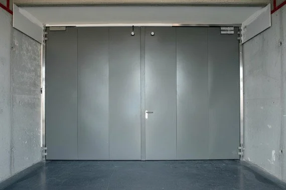 Novoferm Magnum Italian large gray industrial fire-rated double doors in concrete hallway at ArkNova Interiors Paphos Cyprus