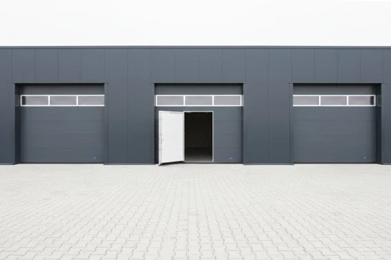 Novoferm Side Doors Italian industrial sectional doors with open side access door at ArkNova Interiors Paphos Cyprus