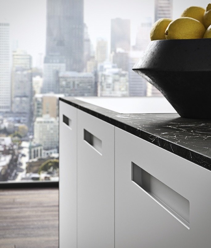 Antares Cucine AS10 CITY Italian design kitchen detail showing white handleless cabinets, black marble countertop and fresh lemons with city skyline in Paphos, Cyprus by ArkNova Interiors