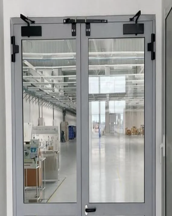 Novoferm Stahglass Italian gray double glass fire-rated doors with closers looking into industrial space at ArkNova Interiors Paphos Cyprus