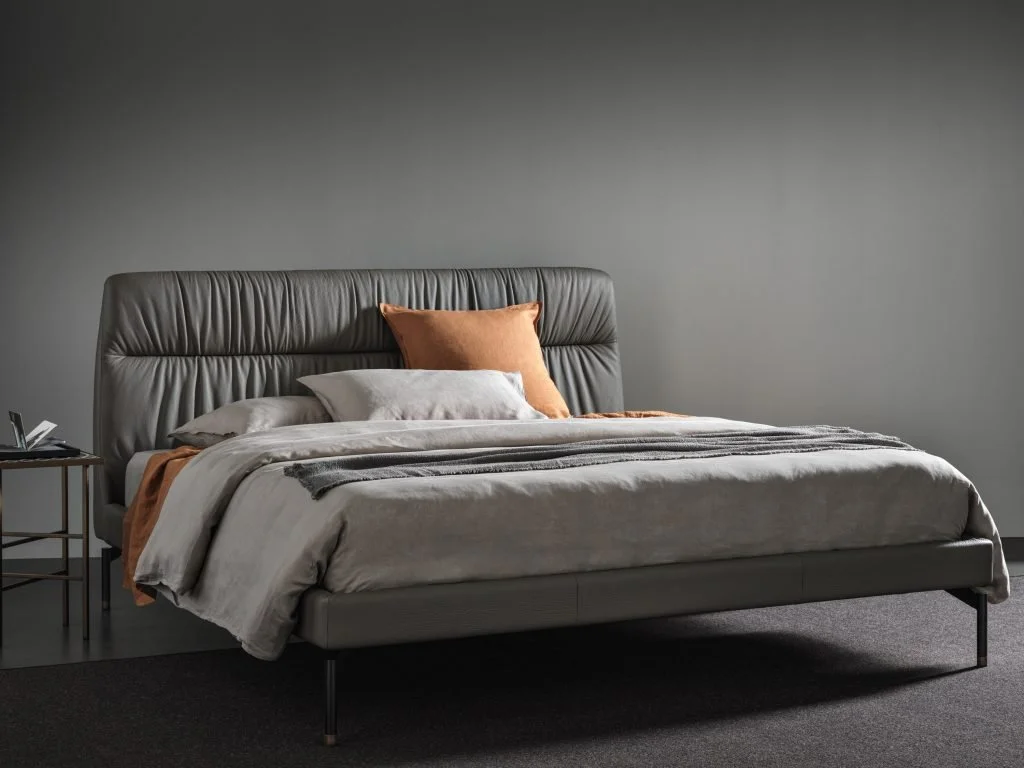Italian Otto bed by Frag with dramatic tall gray ruched leather headboard in modern setting at ArkNova Interiors Paphos showroom in Cyprus