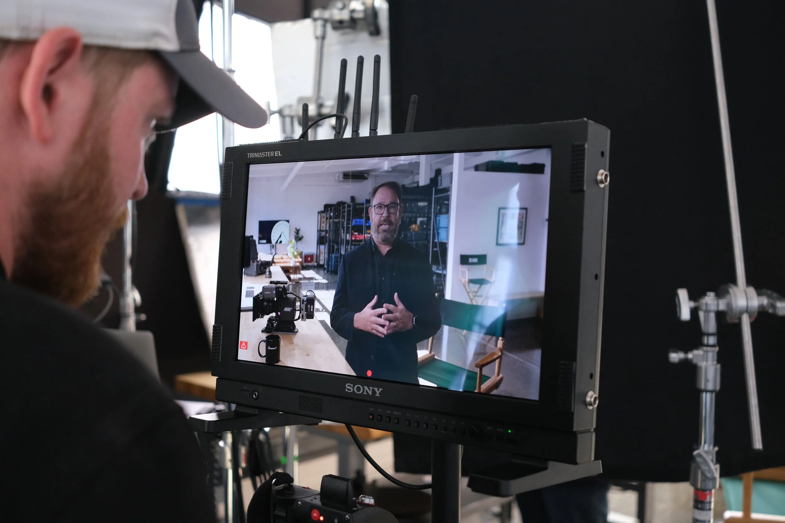 Andrew Henkelman watches Douglas Johnson on a monitor during an internal livestream for Paramount Global.