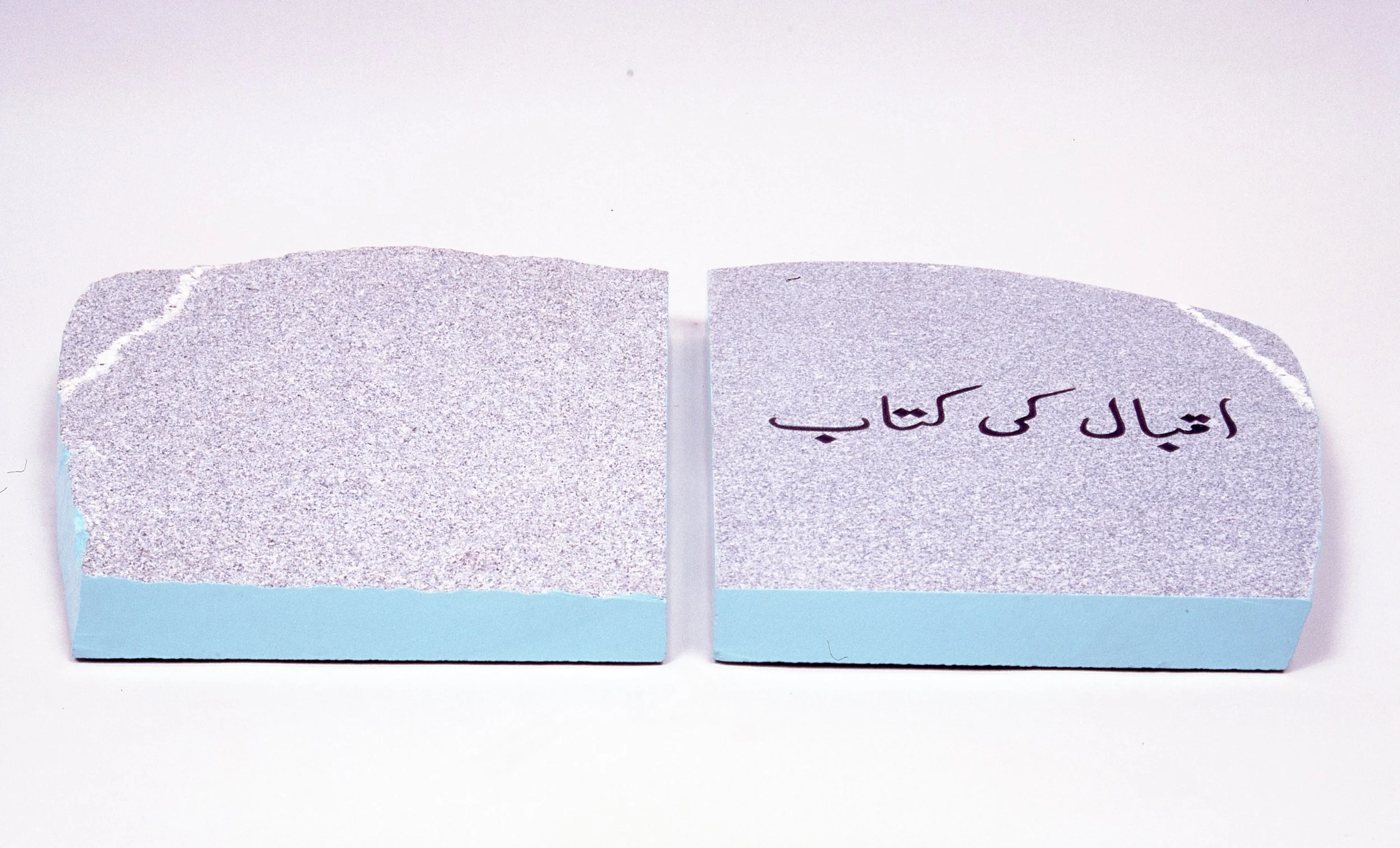 Two erasers, one with Persian text written on it, placed side by side on a white surface.