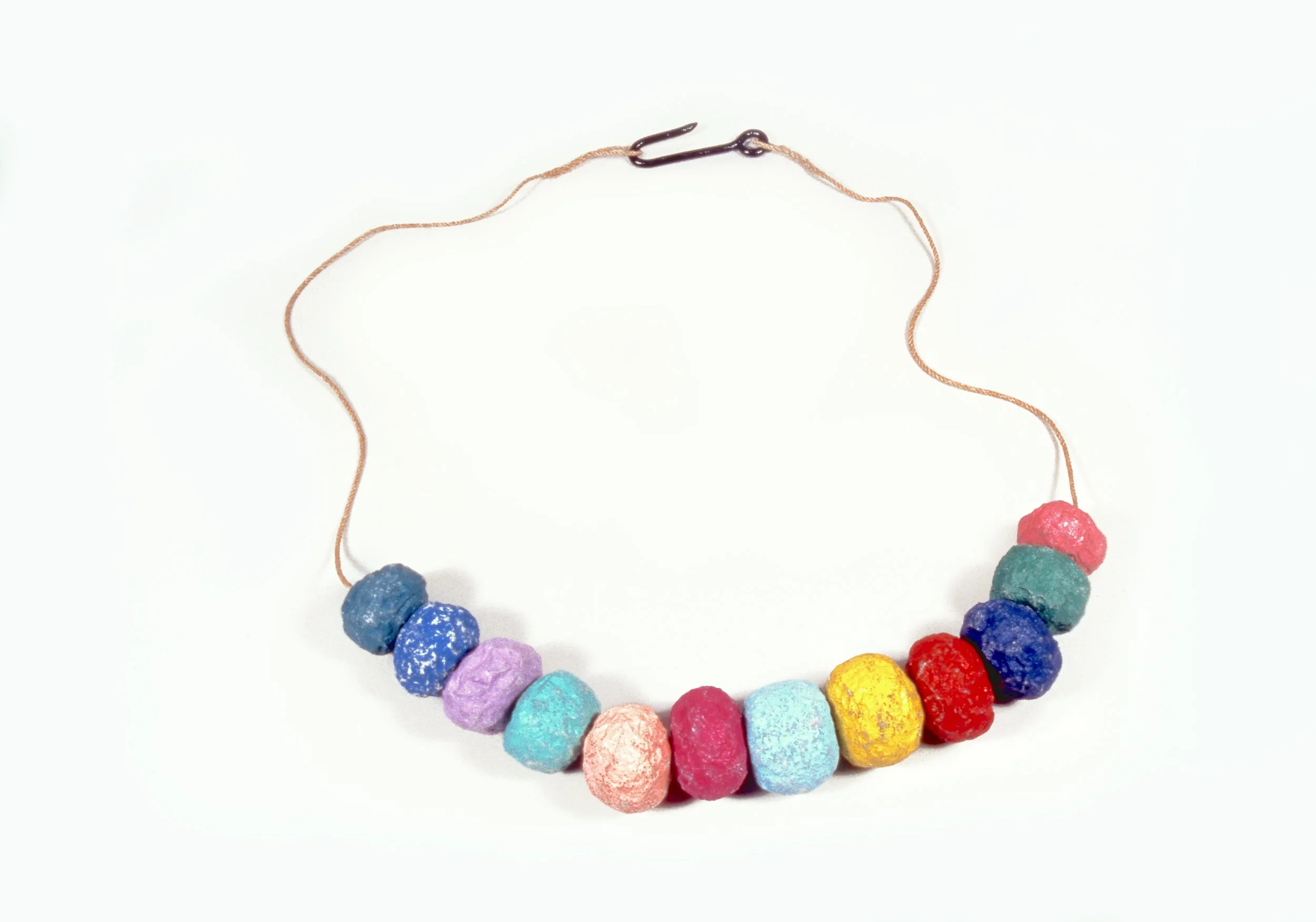 Colorful beaded necklace with textured round beads in pink, blue, purple, teal, yellow, red, and green, with a simple metal hook clasp, laid on a white background.