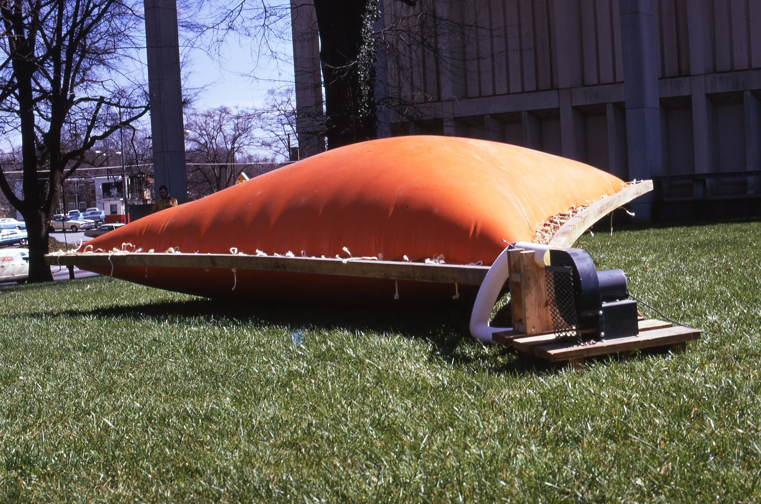 A large orange submarine model on grass with equipment attached to it.