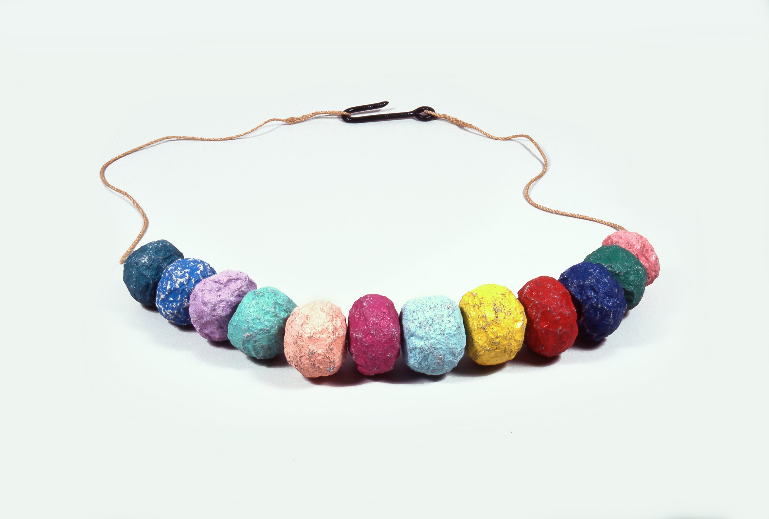Necklace with colorful rock beads in pastel and vibrant shades arranged in a row on a string with a black clasp.