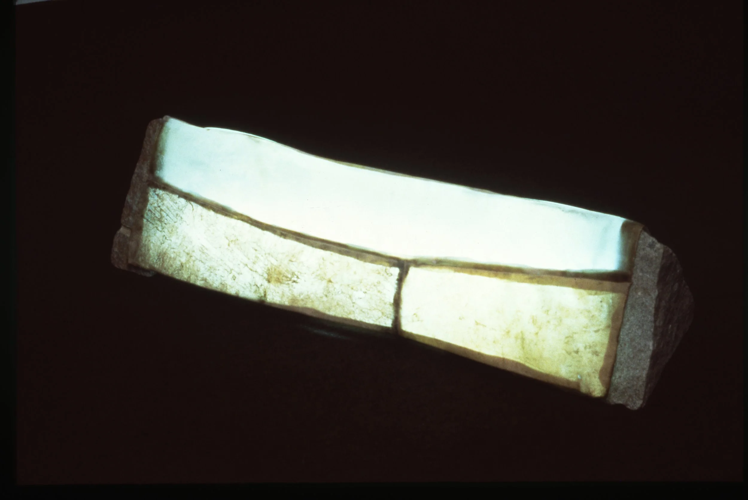 A rectangular stone with integrated glowing ceramic tile, emitting a soft light, set against a dark background.