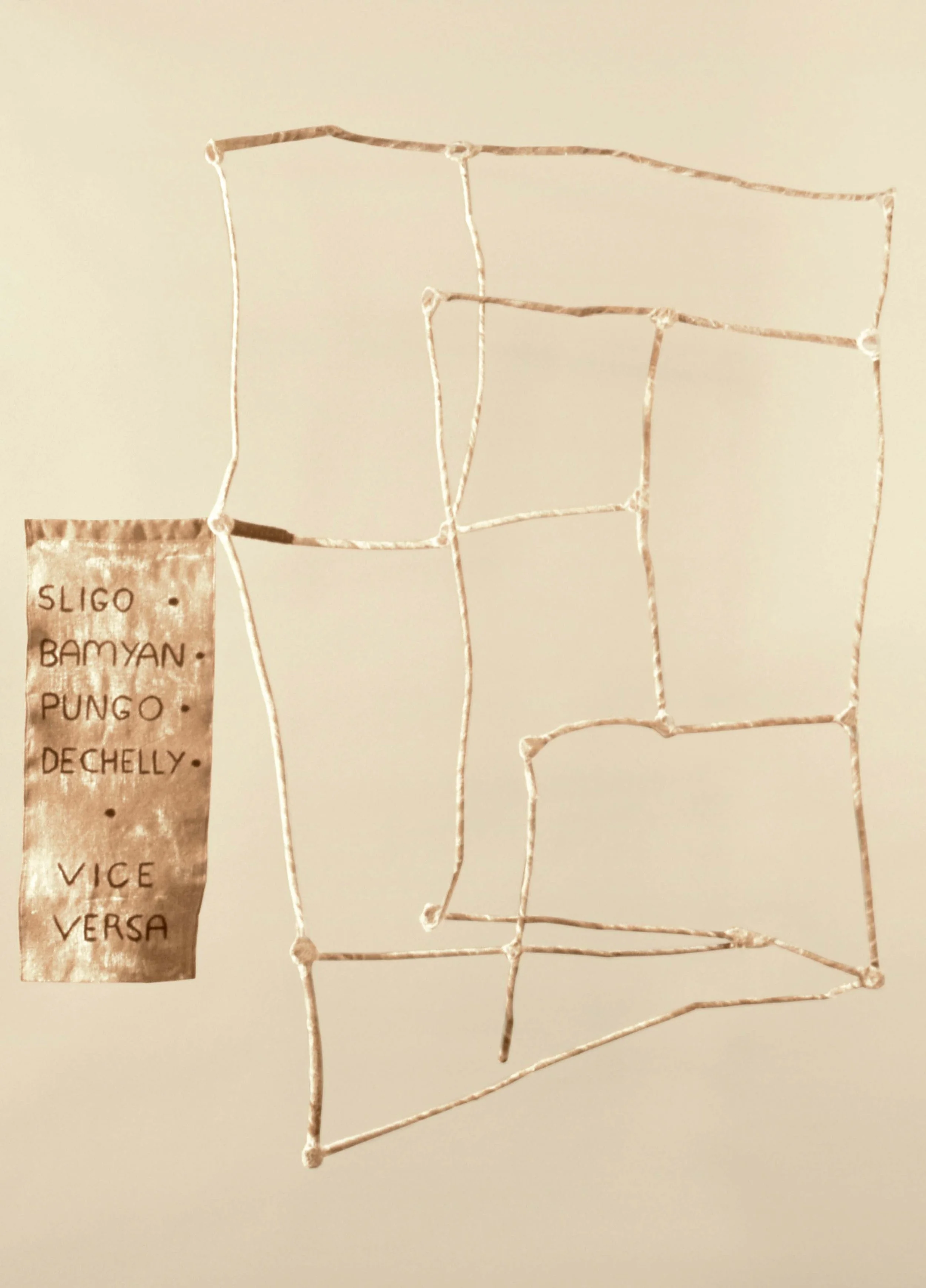 A handmade map made with string outlining regions or districts, with a list of names on a paper attached to the wall.