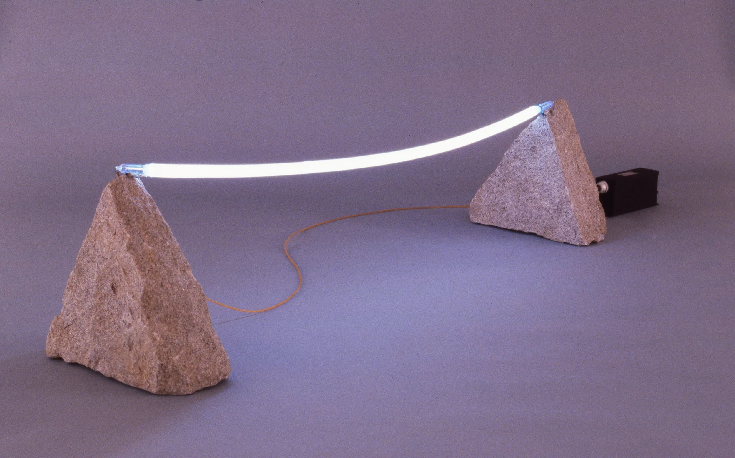 A model of a light beam bouncing between two rocks with a small black motor on the right.