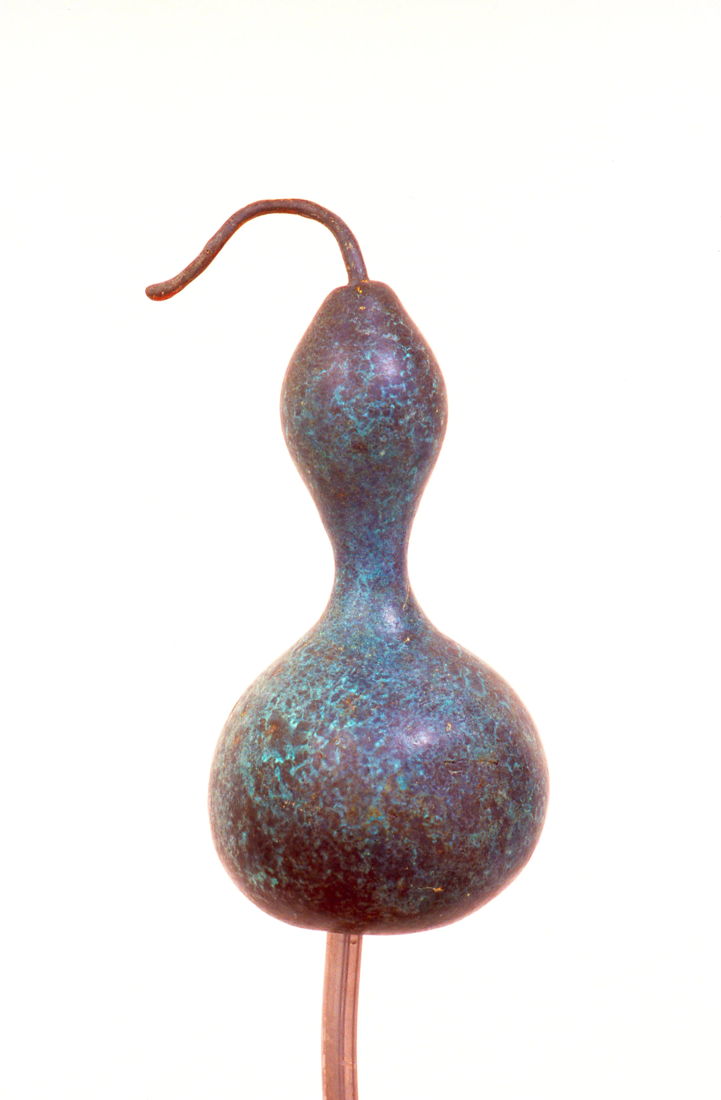 A classical bronze sculpture of a gourd with a curved stem at the top, mounted on a thin rod, against a white background.