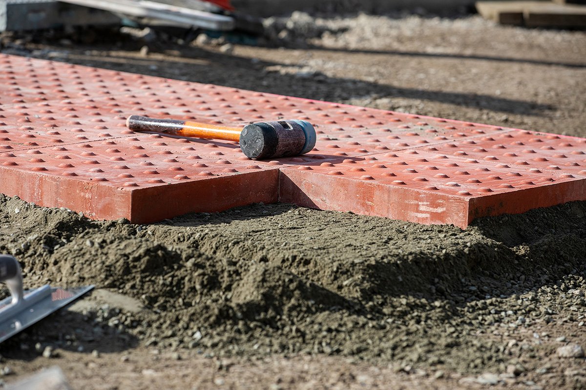 Image of red pavement stone with a mallet on top