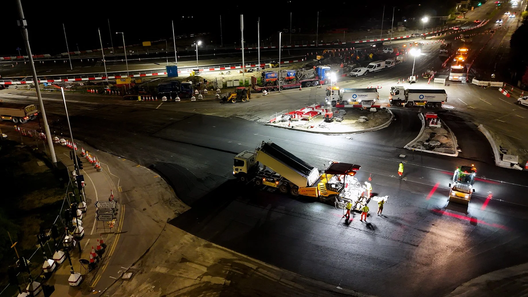 Drone shot of a road paver and tipping wagon resurfacing a road at Dawsons Corner in Leeds