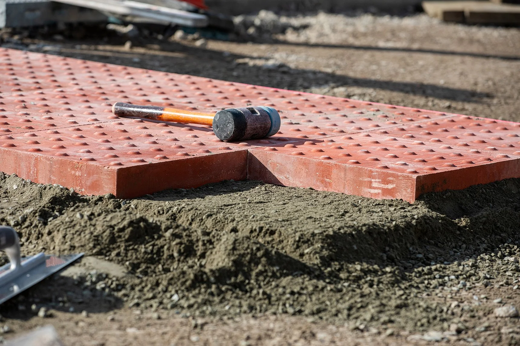 Image of red pavement stone with a mallet on top