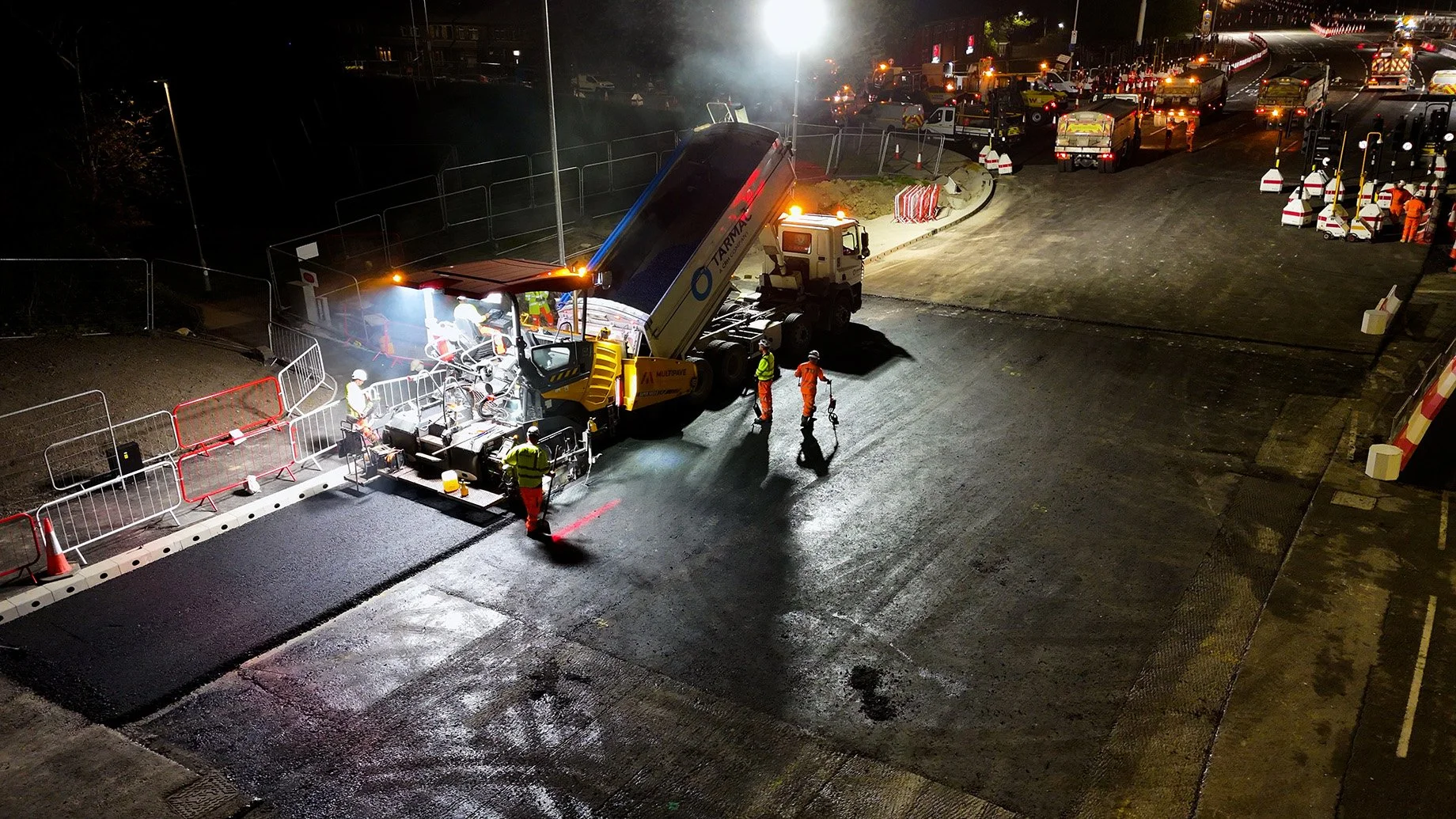 Drone shot of a road paver and tipping wagon resurfacing a road at Dawsons Corner in Leeds