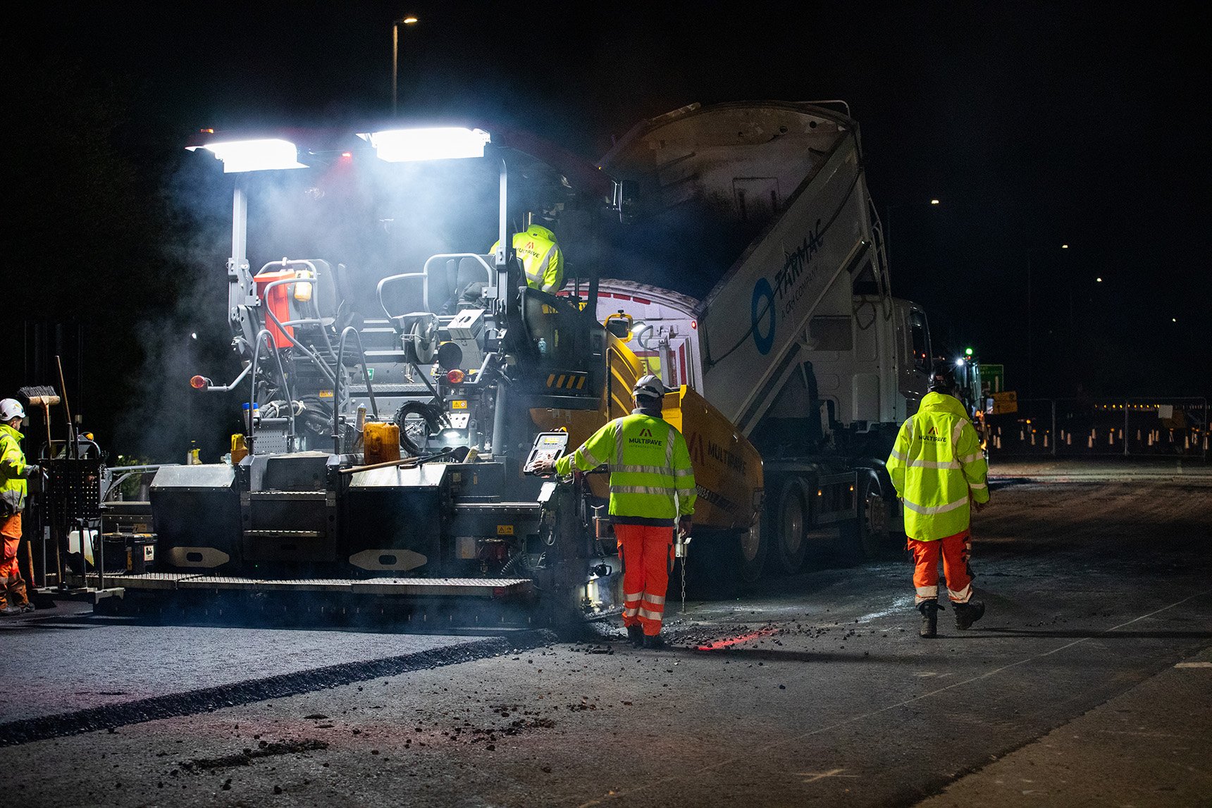 Image of a road paver and tipping wagon resurfacing a road at Dawsons Corner in Leeds
