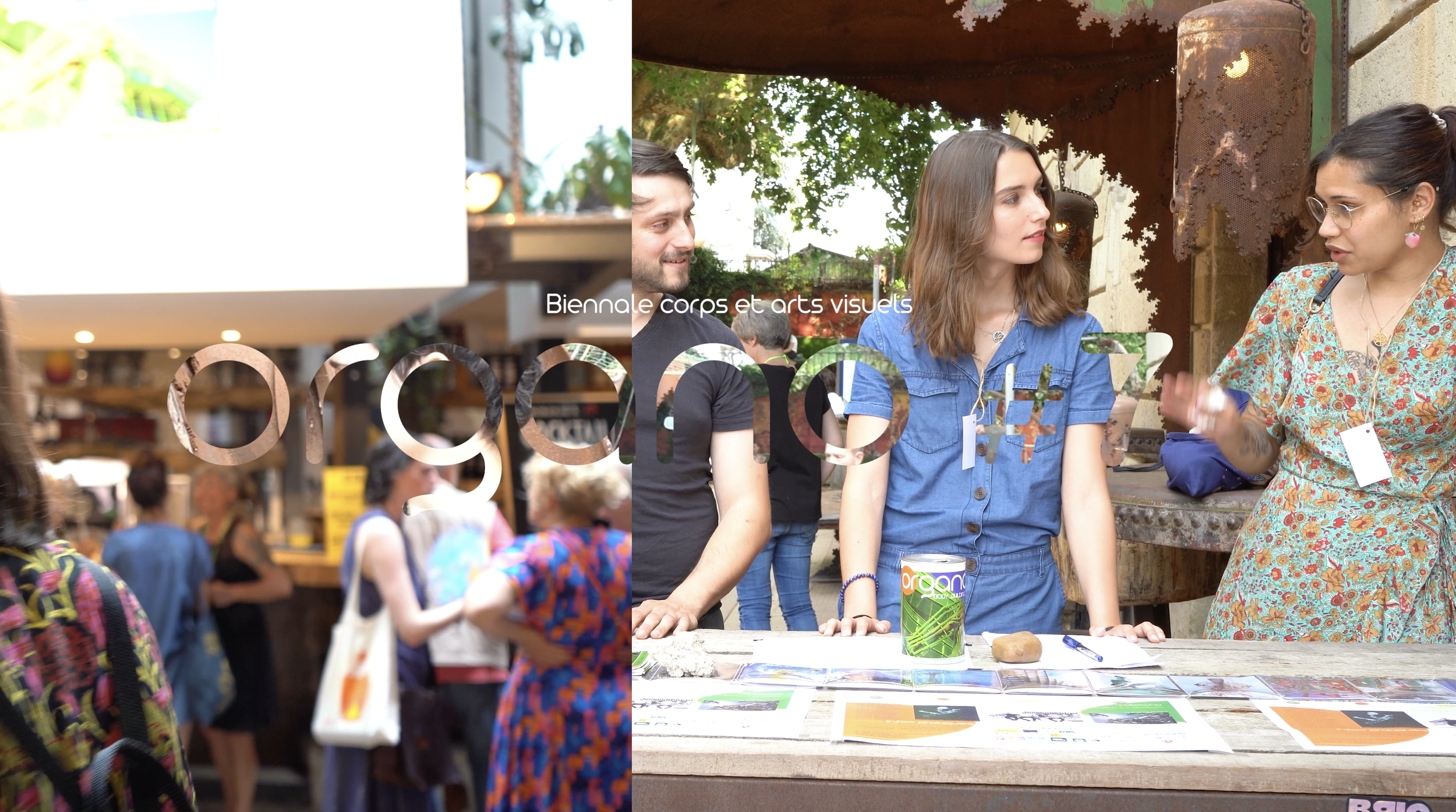 Groupe de personnes lors d'une discussion lors d'un événement, avec affiches et matériel sur une table, sous un abri, avec des arbres en arrière-plan.