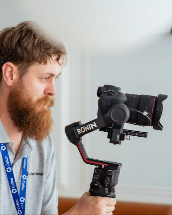 Un homme à barbe utilise une caméra stabilisée Ronin pour filmer.