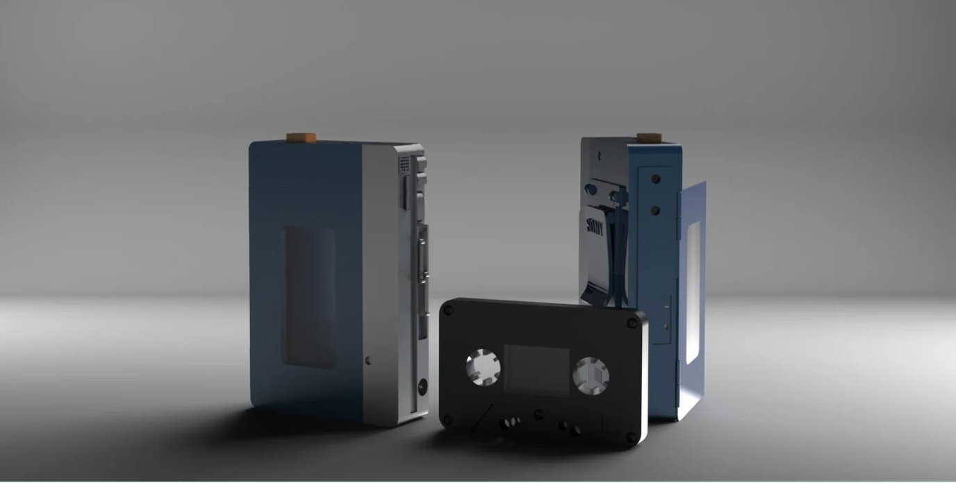 Three vintage cassette tapes, one with an orange label on top, placed on a gray surface with a gray background.