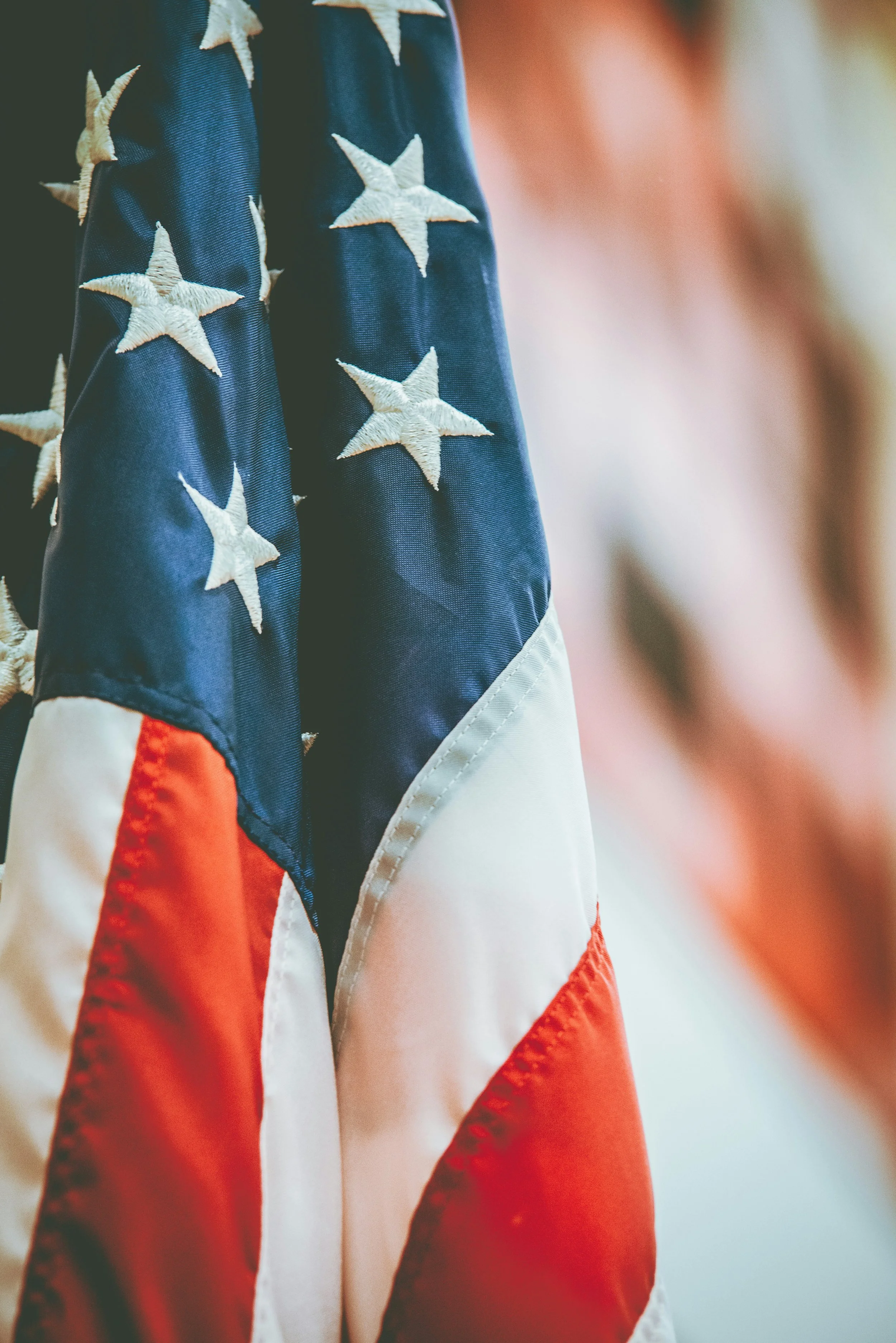 Close-up of a patriotic American flag with white stars on a blue field and red and white stripes.