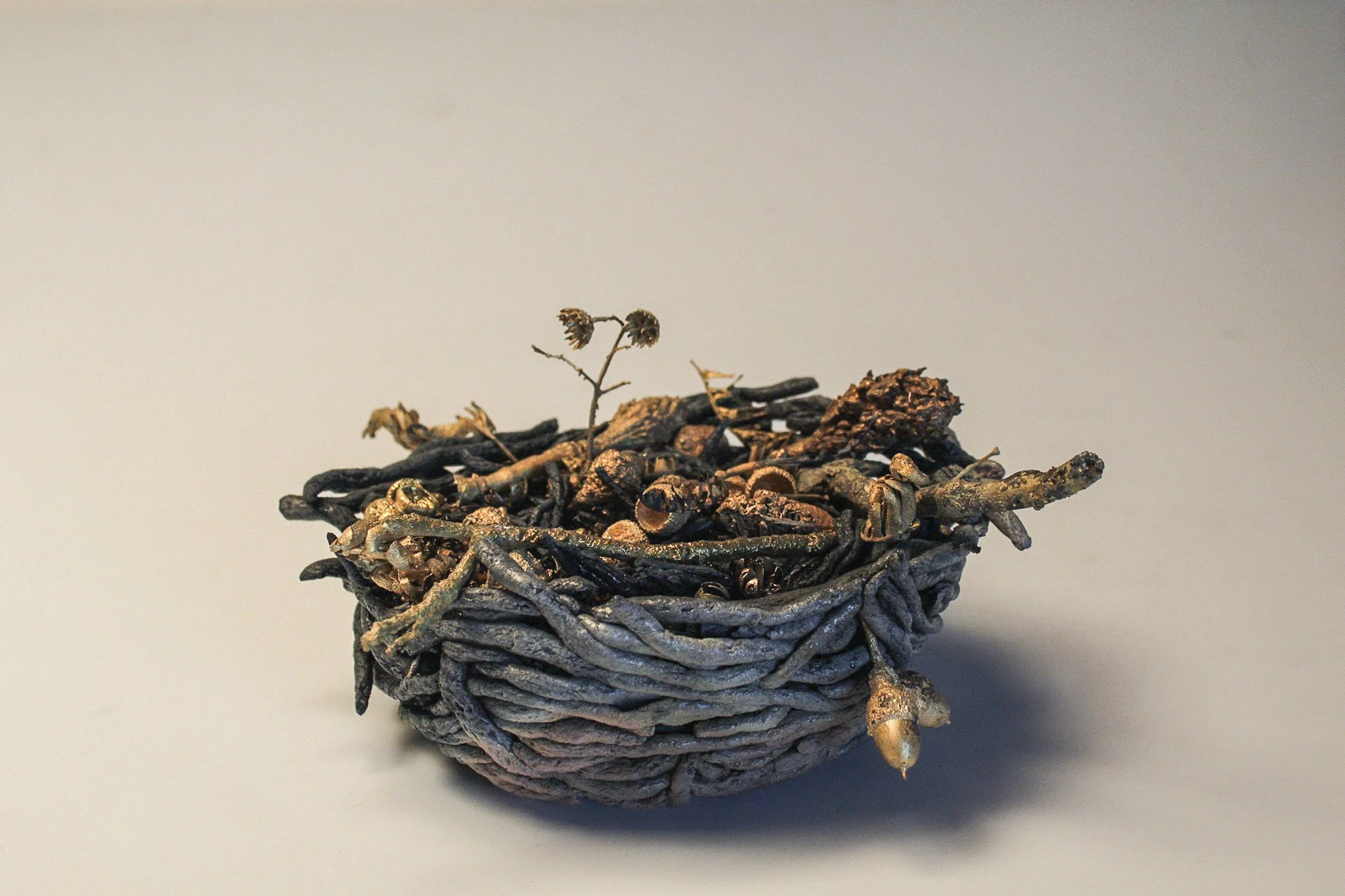 "Molting" (nest - front)
2025
Saggar-fired ceramic, bronze-cast organic material
7” x 6” x 5”