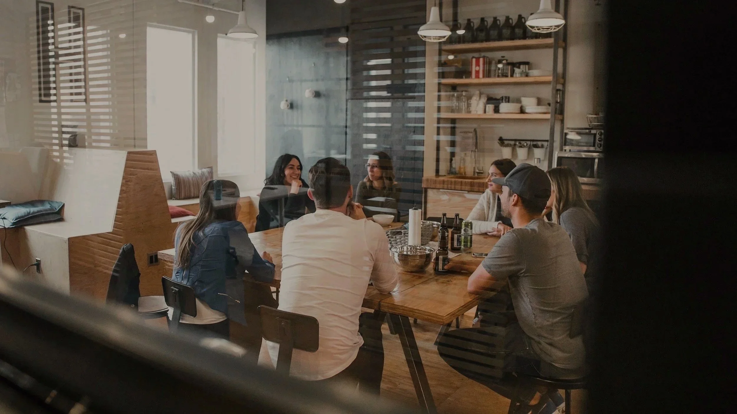 Une formation donnée à un groupe de personnes assises autour d'une grande table, engageant une conversation et partageant sur le thème de la grossesse.