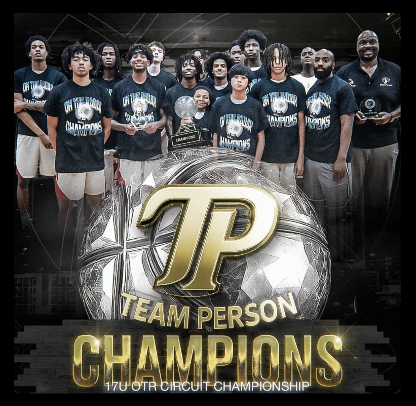 A group of young male basketball players and their coach, wearing black shirts that read "On the Road Champions," celebrating with trophies in front of a large electronic display that says "Team Person Champions" and "17U OTR Circuit Championship."