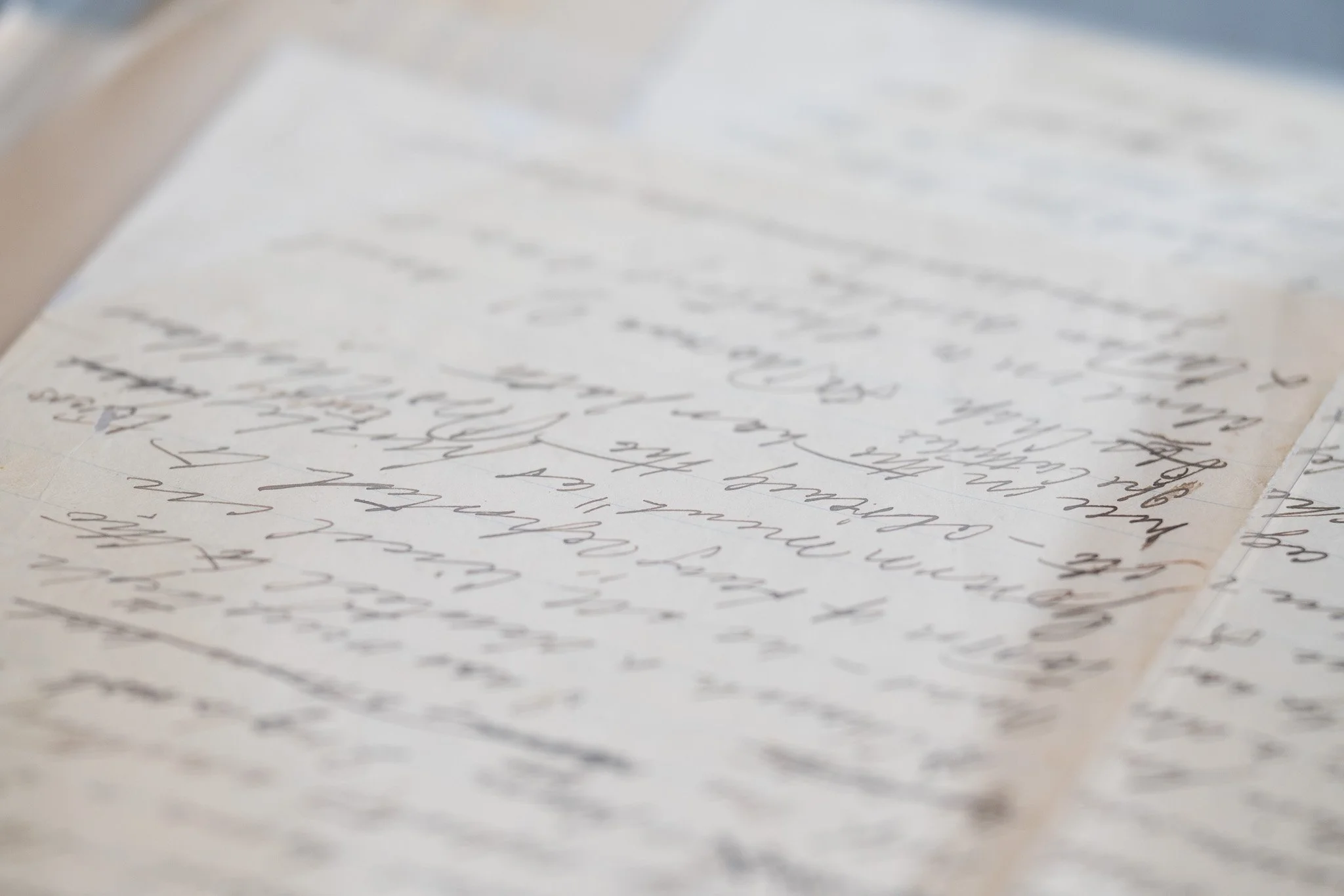 Close-up of handwritten letters on aged paper, showing cursive handwriting.