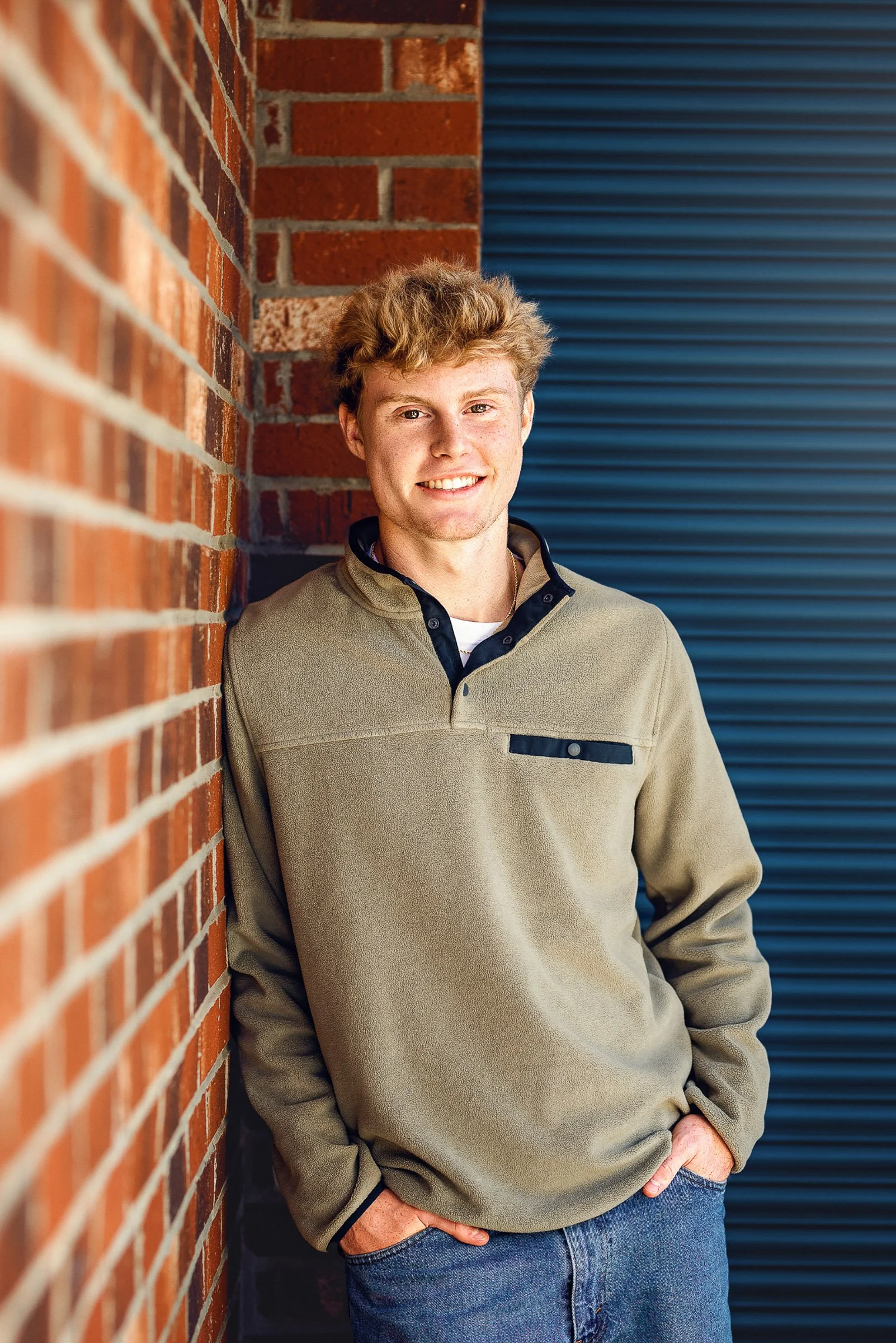 Senior portrait photographer in Concord NC - guy leaning on brick wall by Staci Noel Photography