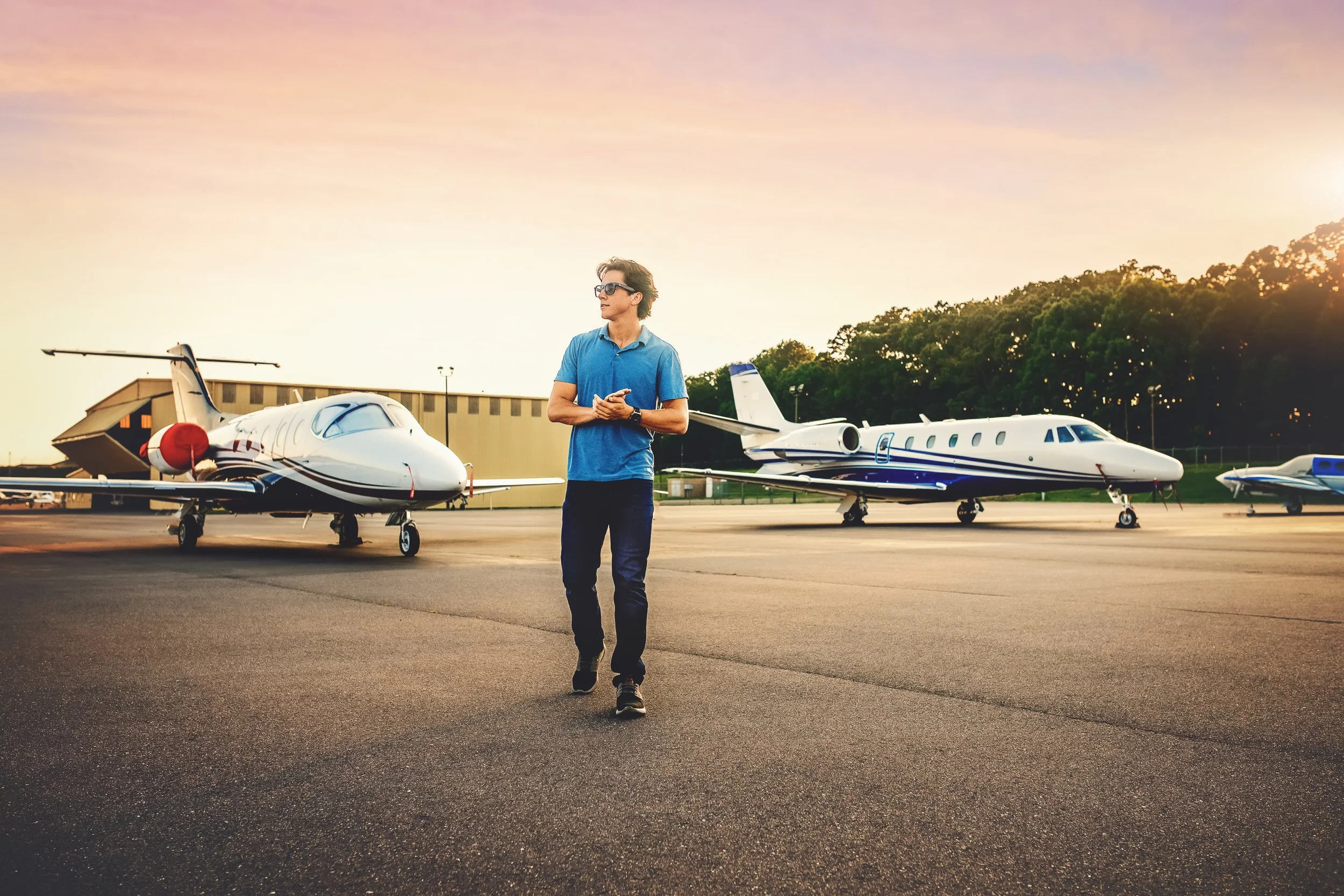 Environmental senior portrait of student pilot Zach with airplanes at Monroe Executive Airport.