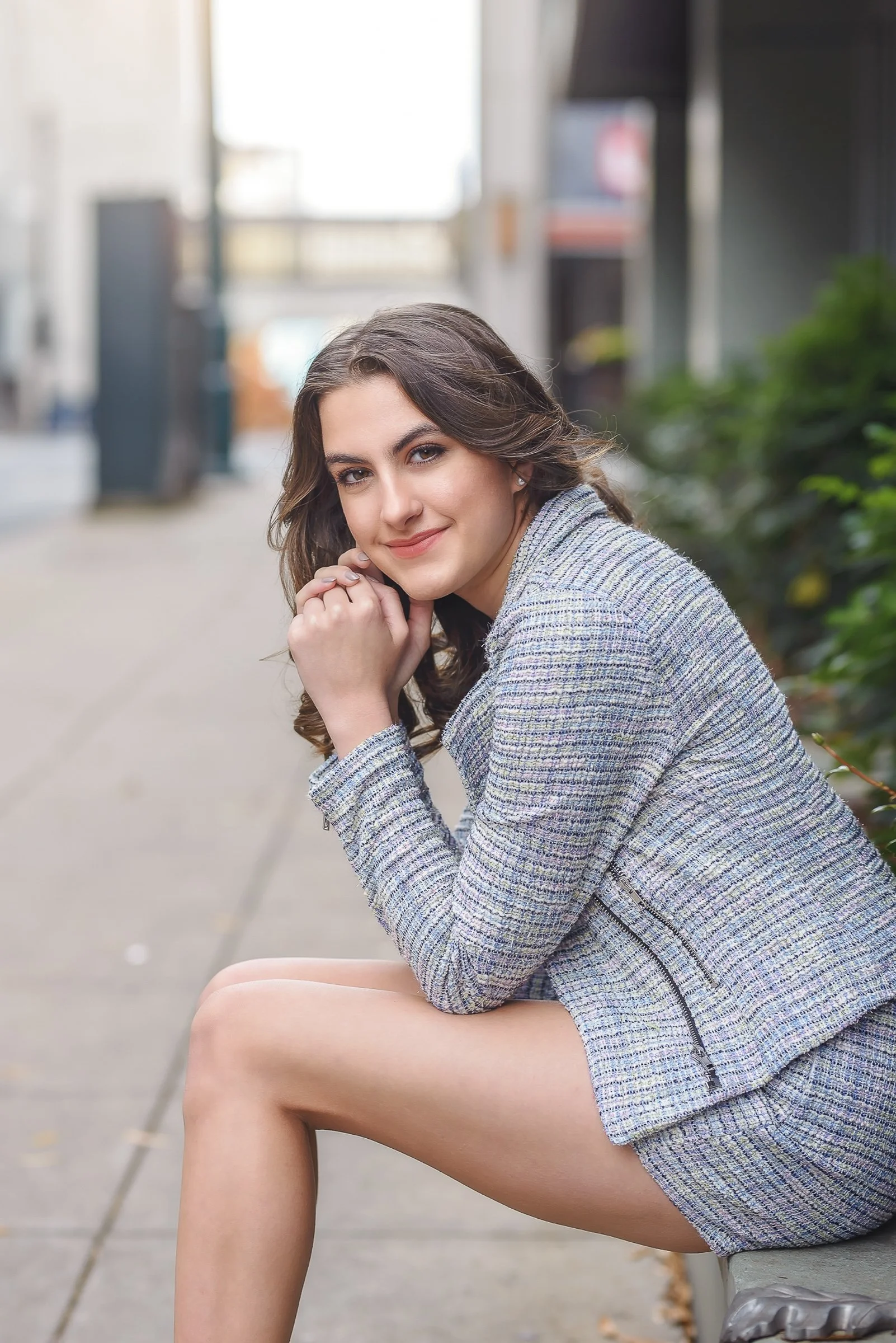 high school senior girl photographed in uptown charlotte in business suit on city street urban background