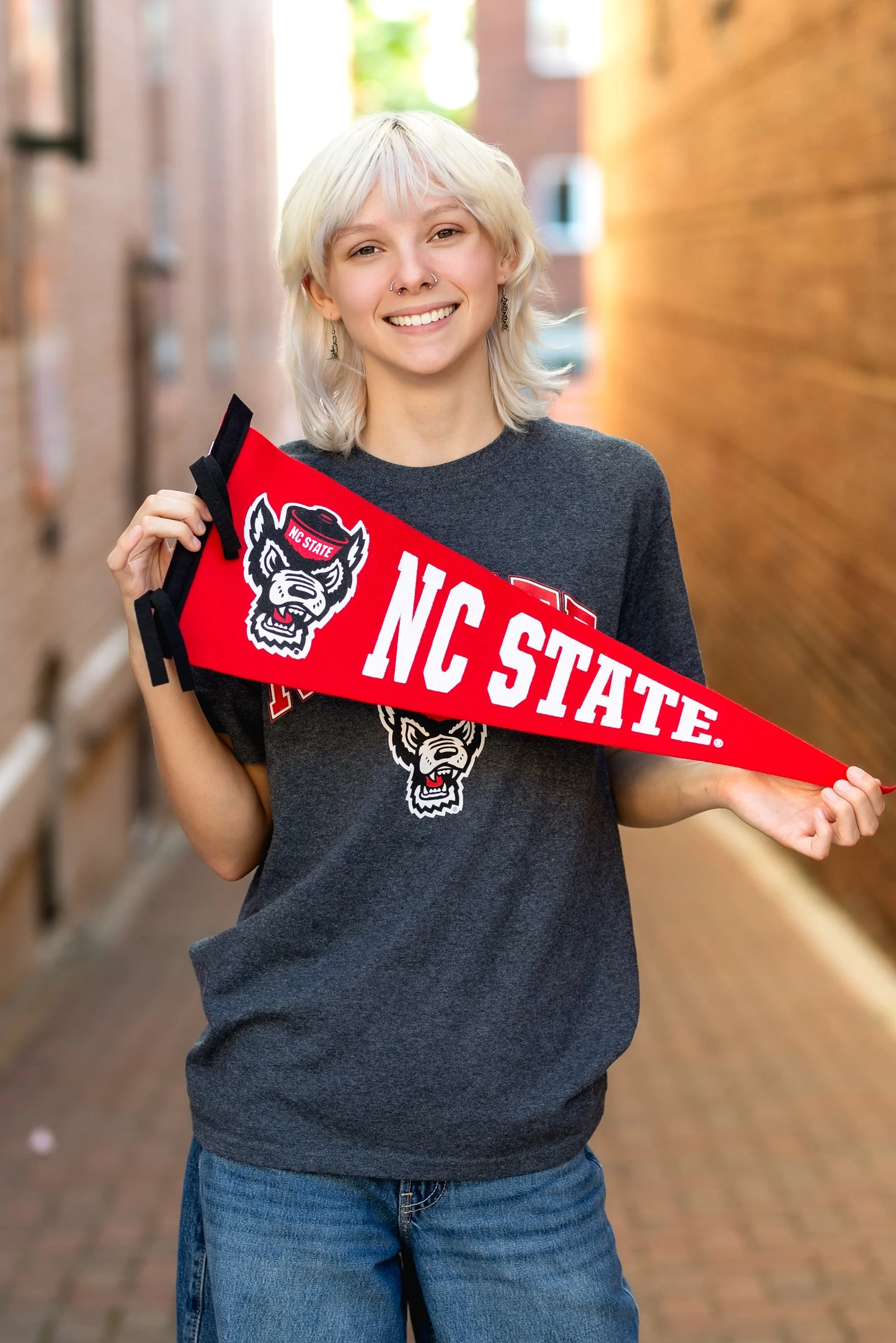 Charlotte NC senior photos - senior girl holding NC State pennant