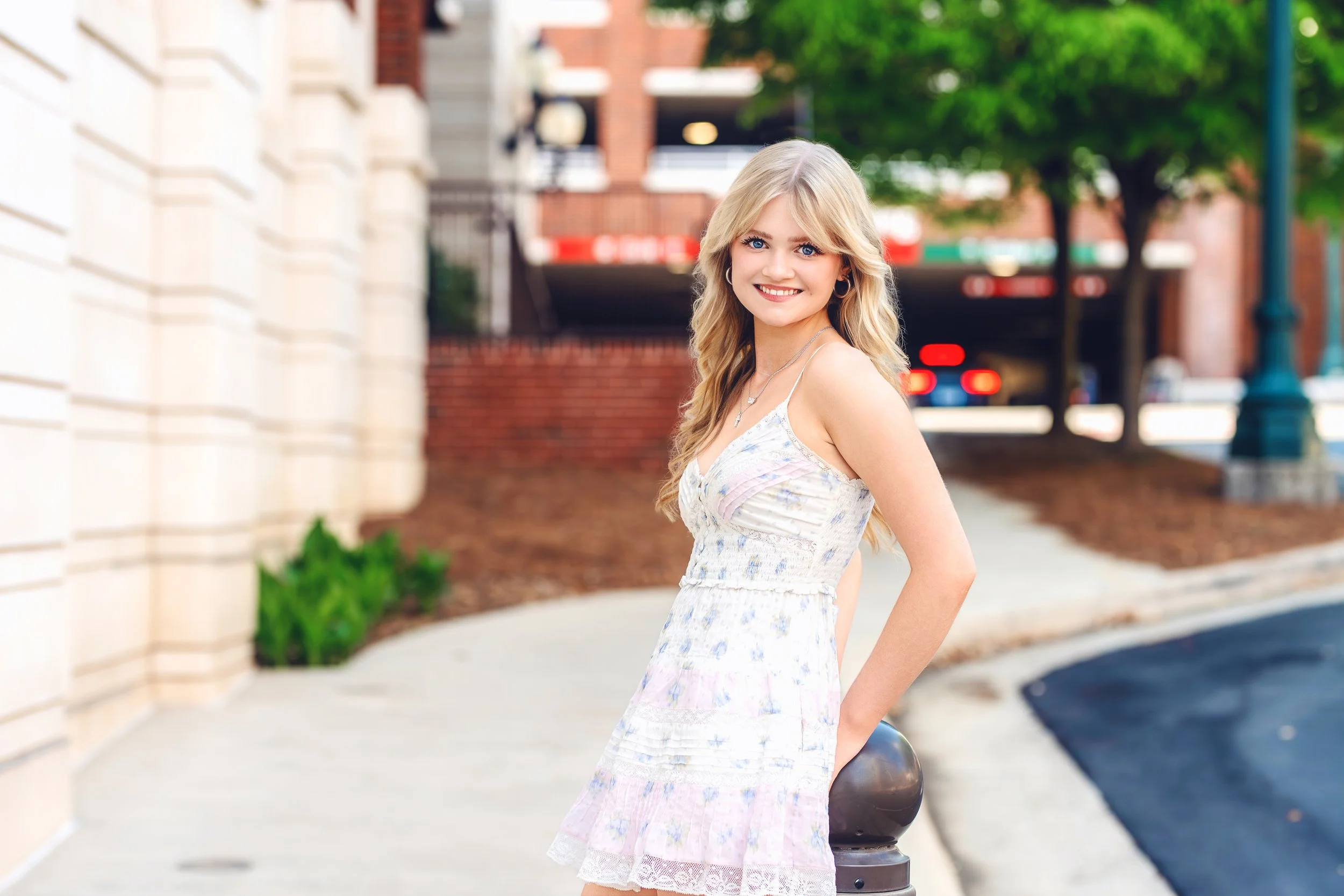 gastonia area senior in concord for senior portraits in floral dress on city sidewalk