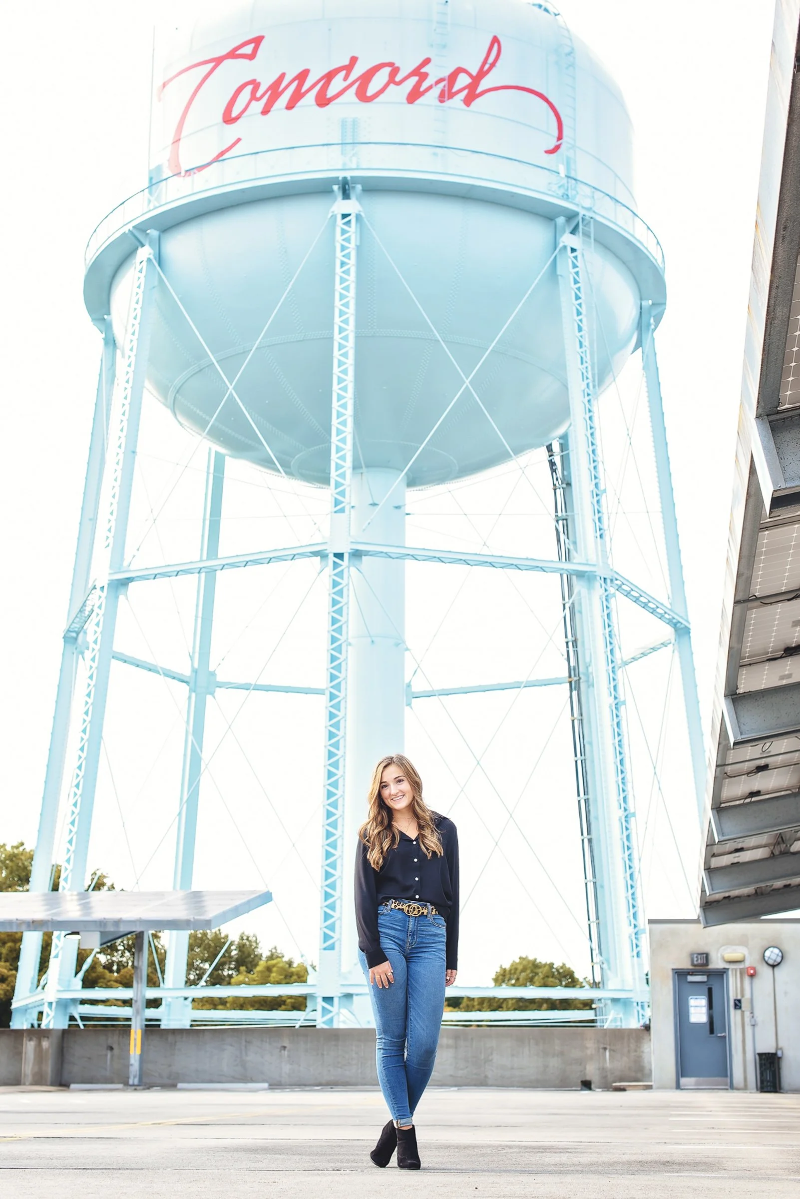 high school senior girl photographed in concord nc in front of downtown water tower 