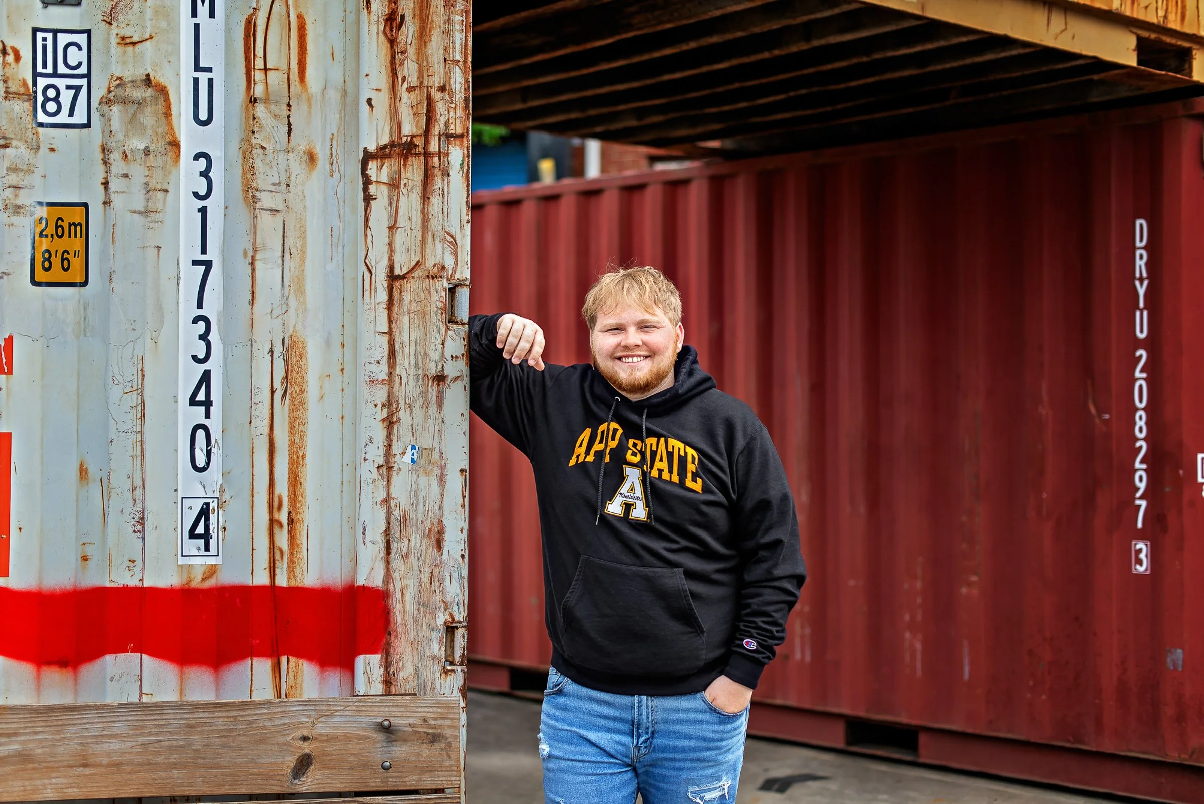 Senior portrait for guys photographed in an urban environment, blending casual confidence, texture, and a modern feel.