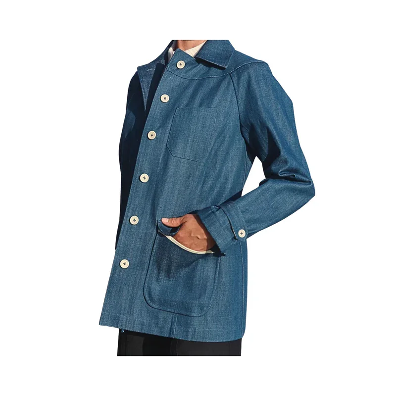 Eine Person trägt eine blaue Jeansjacke mit Knöpfen und einer Brusttasche von Van Tricht.