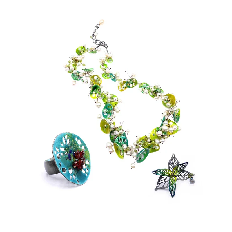 Schmuck aus Silber und Emaille von Nora Kovats in Form von Blumen und anderen Pflanzen.