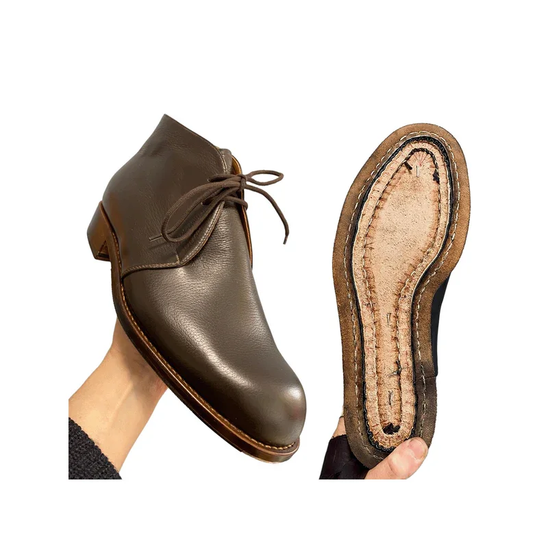 Zwei braune Lederschuhe von Mary Mack werden gehalten, links sieht man von vorne, braunes glattes Leder. Rechts, die Schuhsole von unten. 
